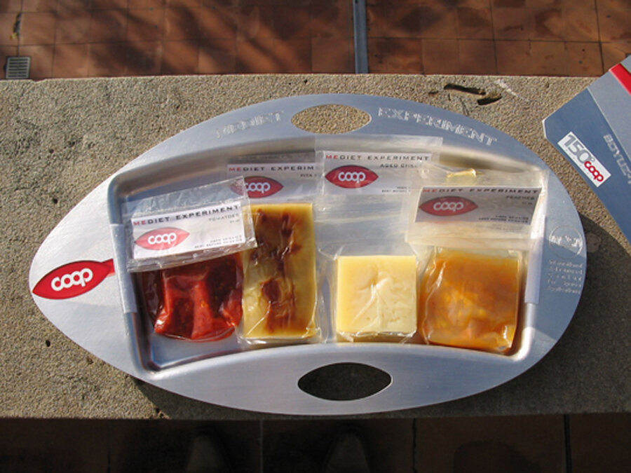 Il vassoio Mediet contiene: dei pomodori secchi, del pane, del formaggio, delle pesche e del cioccolato