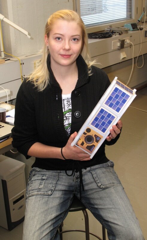 Maria Komu esittelee satelliitin mallia