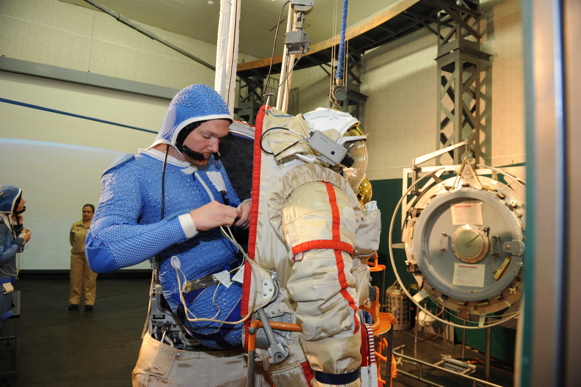Alexander climbing into his spacesuit