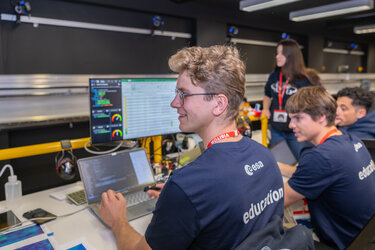 Members of team COCO running their experiment in the Orbital Robotics Lab.